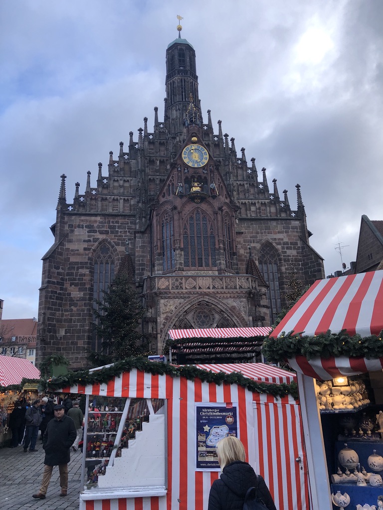 Red-and-white market stalls beneath a church facade in Nuremberg.
