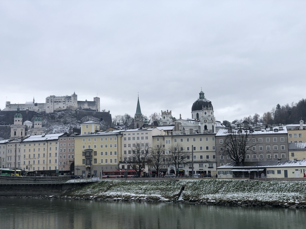 Salzburg’s riverside buildings and hilltop fortress in winter.