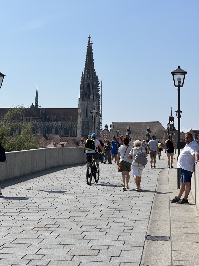 Walking across the bridge toward Regensburg’s cathedral skyline.