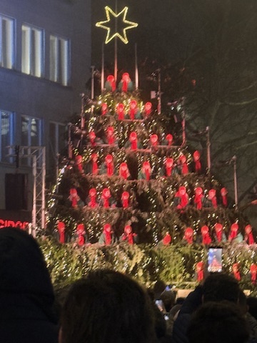Children dressed in red performing on Zurich's illuminated singing Christmas tree